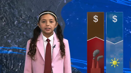 This is a photo of a young girl, in a pink suit jacket, white shirt and maroon tie, standing in front of a weather map, presenting the weather for a TV broadcast