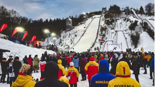 Image of a ski slope with groups of onlookers dressed in Romania-branded anoraks
