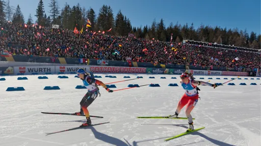 A lively scene at the 2025 Biathlon World Championships women's pursuit race. German biathlete Franziska Preuß and Swiss competitor Lena Häcki-Gross are in action, with a backdrop of cheering fans in the grandstands. Spectators wave flags and banners, creating an electrifying atmosphere.